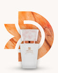 Chogan 027 Extrait de Parfum, weisser Parfumflakon mit rosé marmorierter Verschlusskappe und kupferfarbenem Akzent, mittig vor orangefarbenem D-förmigem Hintergrund mit marmorierter Steinstruktur, Duftfamilie ähnlich Trésor Lancôme.