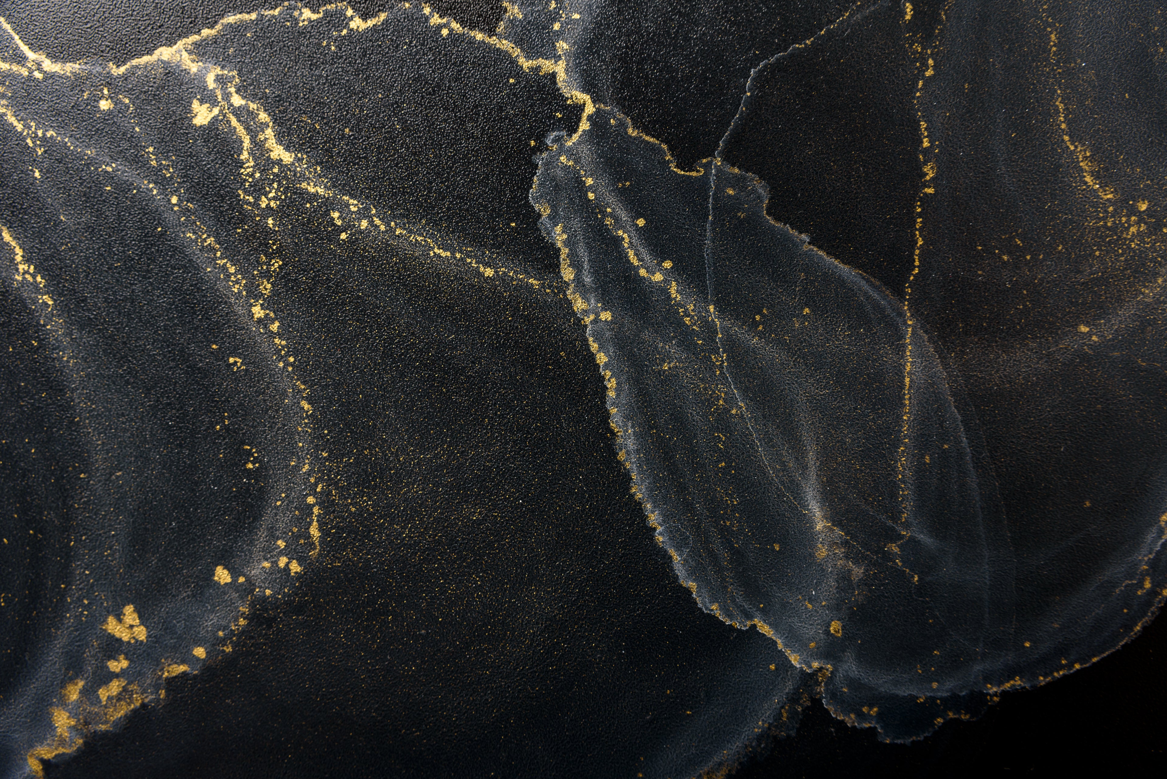 Dunkles abstraktes Hintergrundmotiv mit fliessenden Texturen in Schwarz und Anthrazit, durchzogen von feinen goldenen Akzenten.